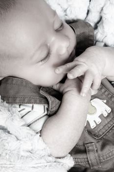 Beautiful newborn baby boy sleeping on a soft blanket