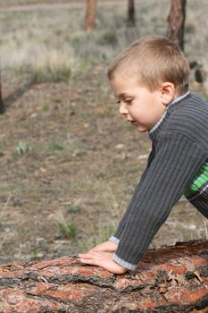 
Little blond boy playing outside in the field