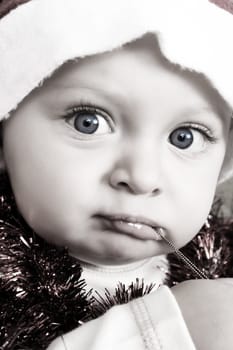 Christmas baby playing with decorations wearing a hat