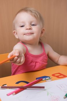 Baby girl coloring with pencils at table