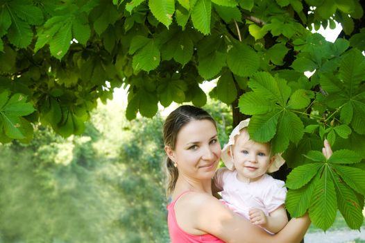 Happy woman and child hugging under chestnut tree