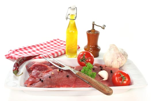 two raw pork steaks on a white platter