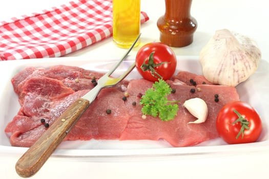 two raw pork steaks on a white platter