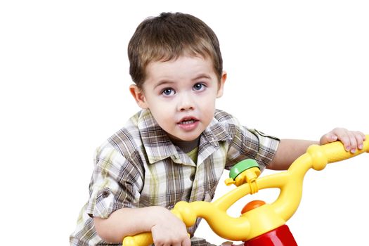 Cute little boy playing by riding a toy bicycle.