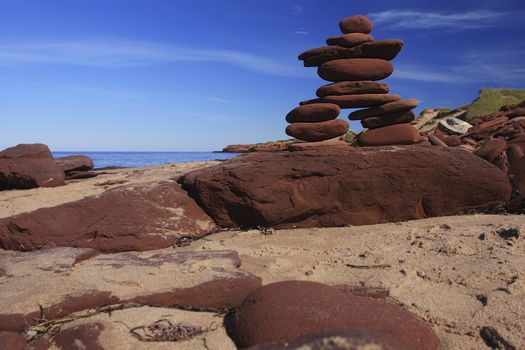 Inukshuk made of Red rocks on a Prince Edward Island Beach Canada