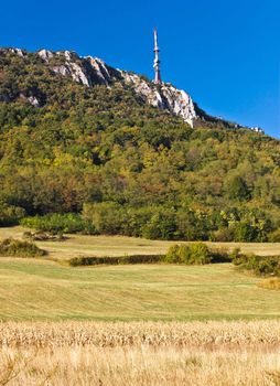 TV tower above beautiful cliffs, forrest & fields on Kalnik mountain, Prigorje county, Croatia - vertical