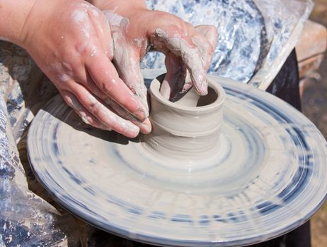 Potter hands working on pottery wheel 