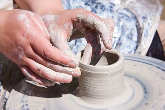 Potter hands working on pottery wheel 