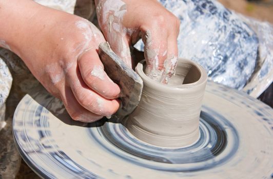 Potter hands working on pottery wheel 