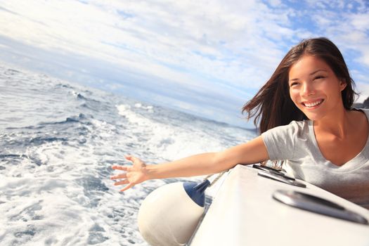 Boat woman smiling happy looking at the sea sailing by. Asian / Caucasian female model.