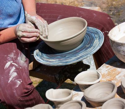 Potter hands working on pottery wheel 