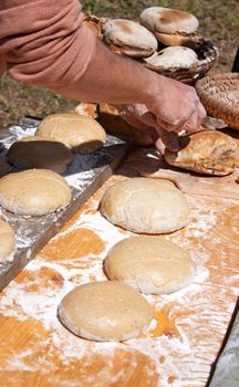 Bakery cutting and cooking some bread outdoor