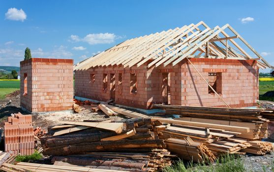 Structure of house in construction, with materials in first plan