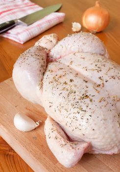 Preparation of a provencal chicken, with aromatic herbs, garlic, onions and tomatoes