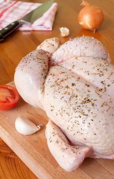 Preparation of a provencal chicken, with aromatic herbs, garlic, onions and tomatoes