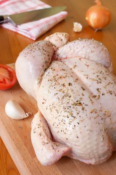 Preparation of a provencal chicken, with aromatic herbs, garlic, onions and tomatoes