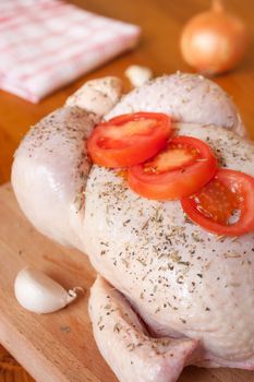 Preparation of a provencal chicken, with aromatic herbs, garlic, onions and tomatoes