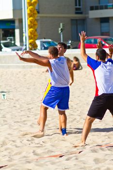 CADIZ, SPAIN - JULY 19: Unidentified players compete in a match between Los Negritos and Ademar Adentro in the 19th league of beach handball of Cadiz on July 19, 2011 in Cadiz, Spain