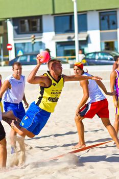 CADIZ, SPAIN - JULY 19: Unidentified players compete in a match between Los Negritos and Ademar Adentro in the 19th league of beach handball of Cadiz on July 19, 2011 in Cadiz, Spain