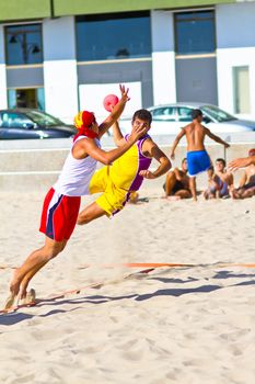 CADIZ, SPAIN - JULY 19: Unidentified players compete in a match between Los Negritos and Ademar Adentro in the 19th league of beach handball of Cadiz on July 19, 2011 in Cadiz, Spain