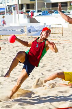 CADIZ, SPAIN - JULY 19: Unidentified players compete in a match between Los Negritos and Ademar Adentro in the 19th league of beach handball of Cadiz on July 19, 2011 in Cadiz, Spain