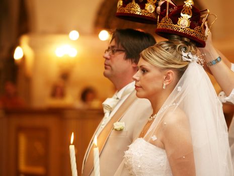 The groom and the bride with candles. Wedding ceremony in church