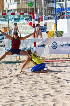 CADIZ, SPAIN - JULY 19: Unidentified players compete in a match between Los Negritos and Ademar Adentro in the 19th league of beach handball of Cadiz on July 19, 2011 in Cadiz, Spain