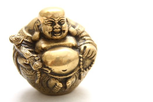 Portrait of a gold laughing buddha statuette.