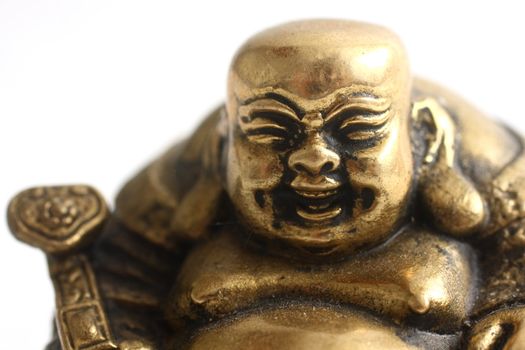 Portrait of a gold laughing buddha statuette.