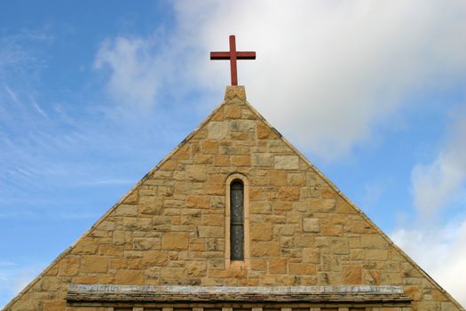 Side view of a church roof with a cross on top