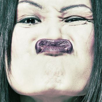 Studio portrait of a asian girl makingh a funny face