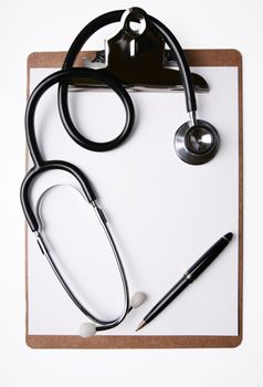 Stethoscope and pen on clipboard with blank sheet of paper