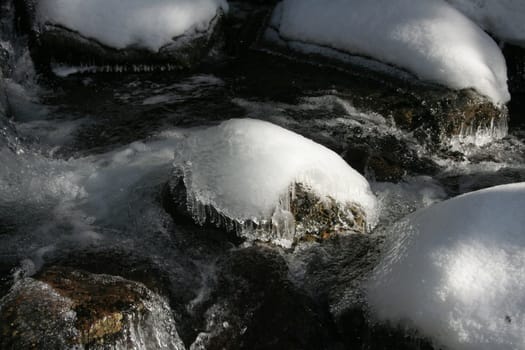 Winter creek with snow-ice bumps