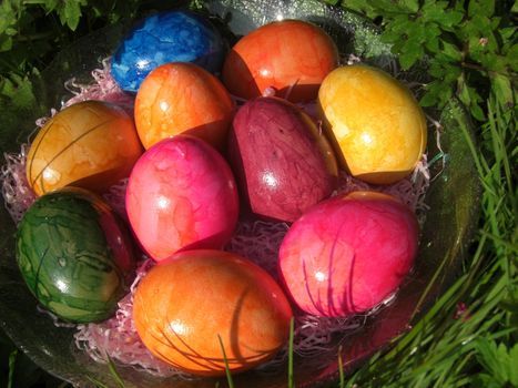 colored easter eggs on a glass dish in the garden