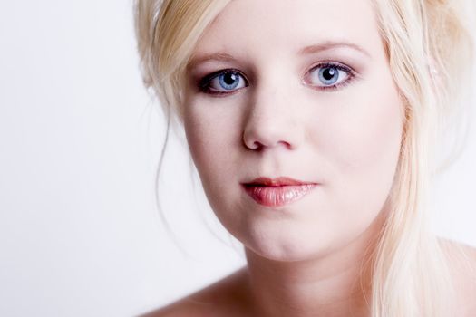 Studio portrait of a blond young lady with bright blue eyes