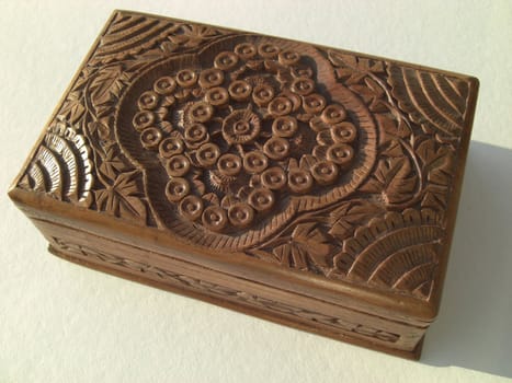 Wooden oriental box on light background, woodcarving with floral ornaments