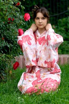 Girl in a pink yukata near rosebush
