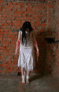 The young girl in a brick cellar with the stained with blood hands