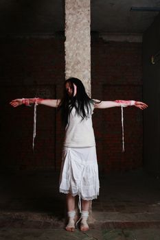 The young girl in a brick cellar with the stained with blood hands