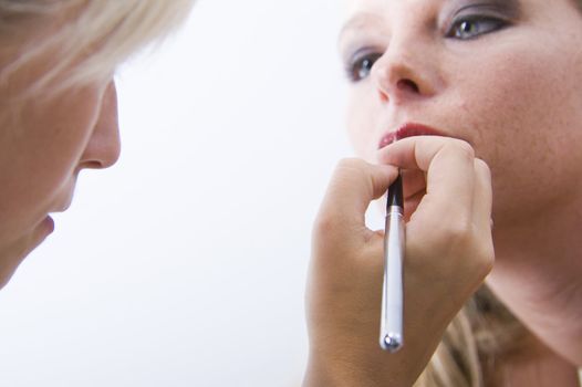 Studio portrait of a beautyfull blond model with her make-up artist