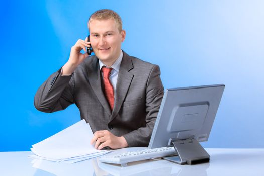 Young successful business man with a telephone and computer