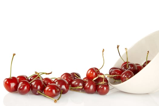 Sweet red cherries and ceramic bowl isolated on a white background