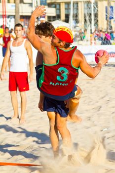 CADIZ, SPAIN - JULY 19: Unidentified players compete in a match between Los Negritos and Autoescuela Barquin in the 19th league of beach handball of Cadiz on July 19, 2011 in Cadiz, Spain
