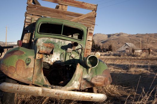 An old abandoned vintage delivery truck van in a field