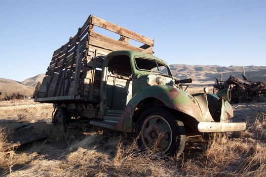 An old abandoned vintage delivery truck van in a field