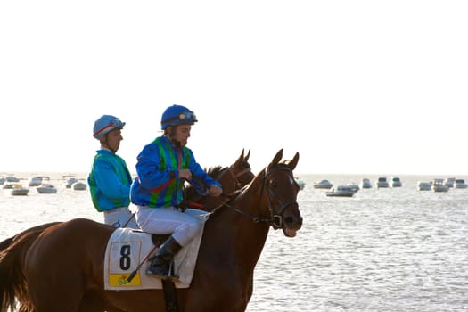 SANLUCAR DE BARRAMEDA, CADIZ, SPAIN - AUGUST 10: Unidentified riders at the start of race horses on Sanlucar de Barrameda beach on August 10, 2011 in Sanlucar de Barrameda, Cadiz, Spain.