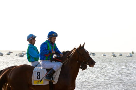 SANLUCAR DE BARRAMEDA, CADIZ, SPAIN - AUGUST 10: Unidentified riders at the start of race horses on Sanlucar de Barrameda beach on August 10, 2011 in Sanlucar de Barrameda, Cadiz, Spain.
