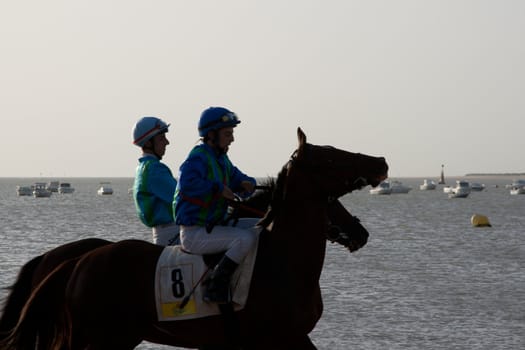 SANLUCAR DE BARRAMEDA, CADIZ, SPAIN - AUGUST 10: Unidentified riders at the start of race horses on Sanlucar de Barrameda beach on August 10, 2011 in Sanlucar de Barrameda, Cadiz, Spain.