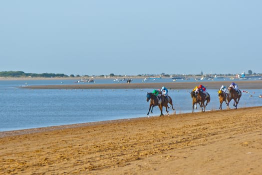 SANLUCAR DE BARRAMEDA, CADIZ, SPAIN - AUGUST 10: Unidentified riders at the start of race horses on Sanlucar de Barrameda beach on August 10, 2011 in Sanlucar de Barrameda, Cadiz, Spain.