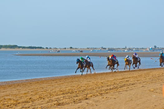 SANLUCAR DE BARRAMEDA, CADIZ, SPAIN - AUGUST 10: Unidentified riders at the start of race horses on Sanlucar de Barrameda beach on August 10, 2011 in Sanlucar de Barrameda, Cadiz, Spain.